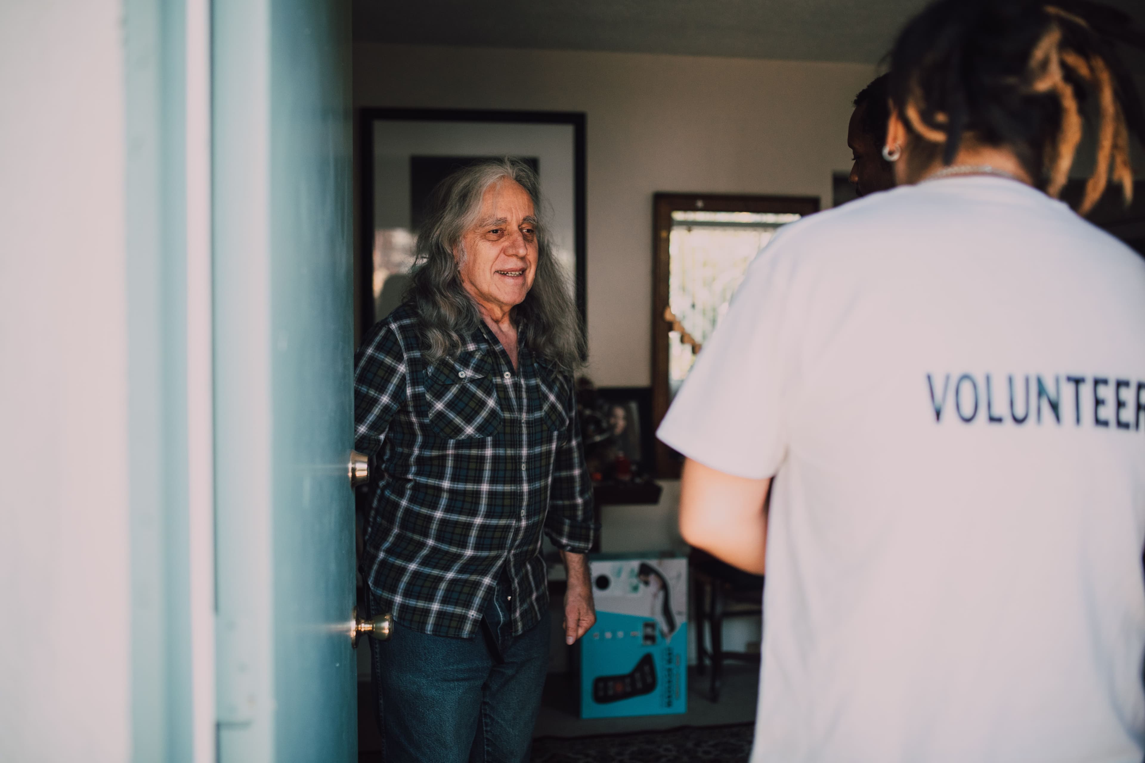 A visitor arriving at an older person’s front door